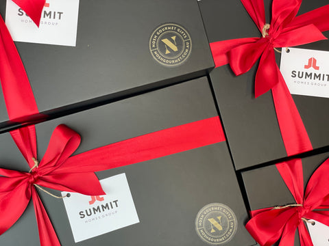 Sleek black hamper boxes with red ribbon and a company logo